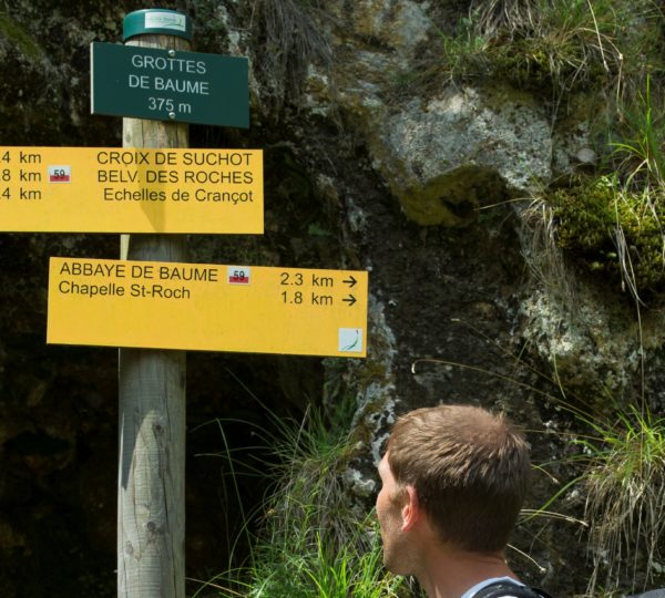 Randonneur devant un poteau de rando