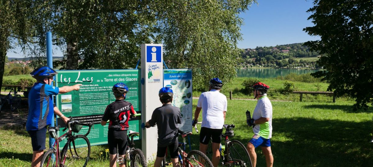 Cyclistes devant un panneau d’information
