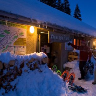 Randonneurs en raquettes entrant au chalet de la Frasse