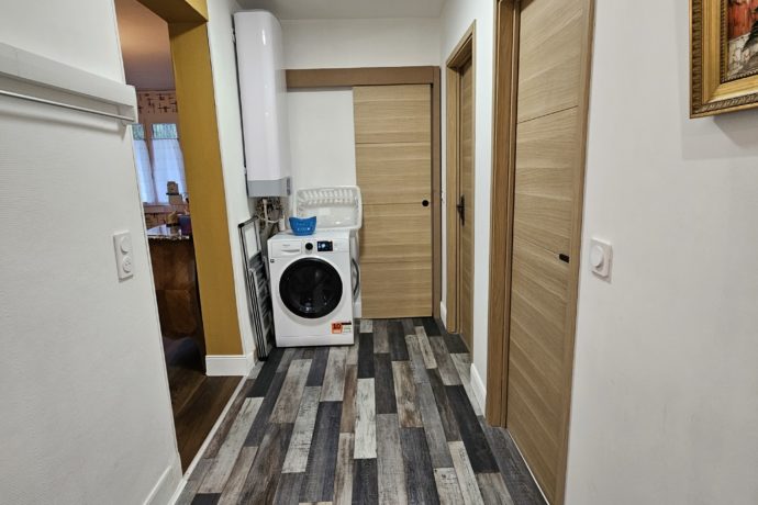 Entrée salle d&rsquo;eau avec lave linge séchant à gauche