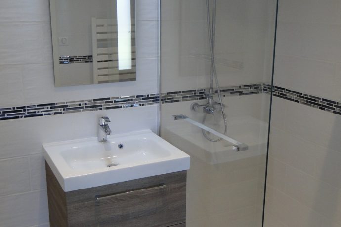 Salle de bains : douche italienne, vasque, miroir.
