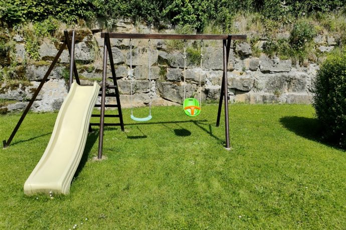 Aire de jeux pour enfants : balançoire, toboggan, siège bébé.